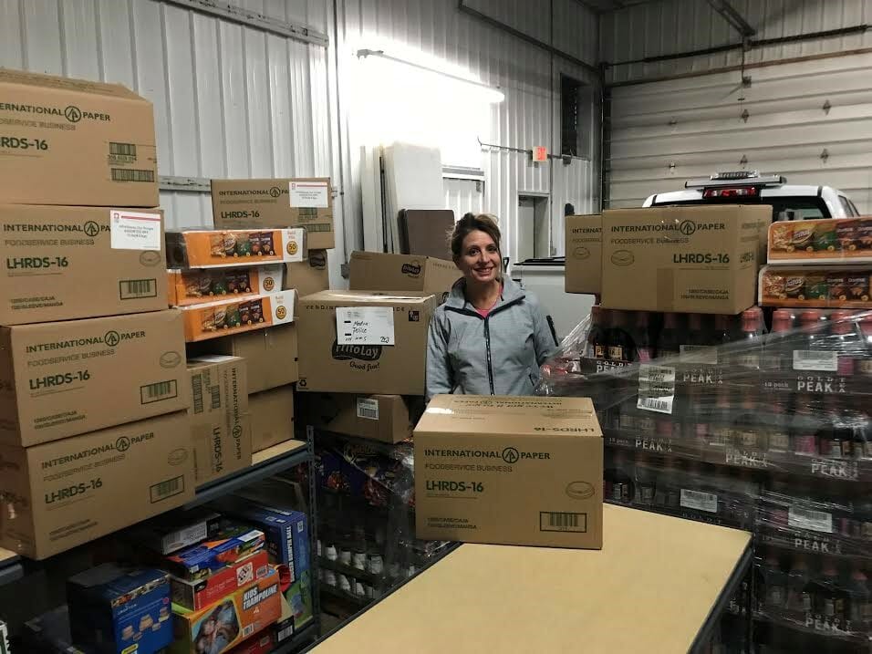 Renee stands with the many boxes of food she’s packed to provide two meals for a week for the 21 families in the MCPAL food pantry program./Courtesy Renee Haberfield