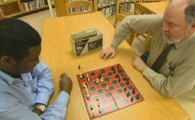 Orrin Hudson plays a game of chess with his former teacher and mentor, James Edge.