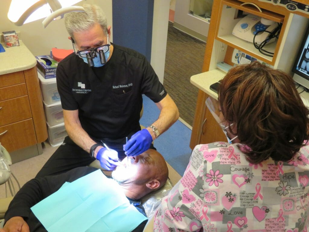 Dr. Richard A. Weinman performs a periodic exam for a patient getting his teeth cleaned.