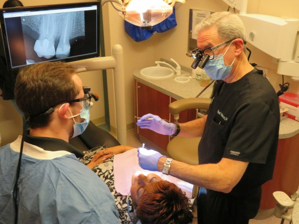 Dr. Richard Weinman teaches a fourth year dental student as he reviews a patient’s treatment, and discusses further treatment options.