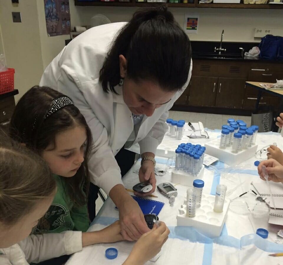 Lori Morton assisting students with a classroom experiment./Courtesy Lori Morton
