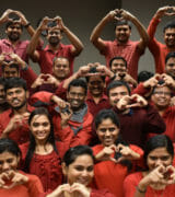 A group of people holding up hearts with their hands.