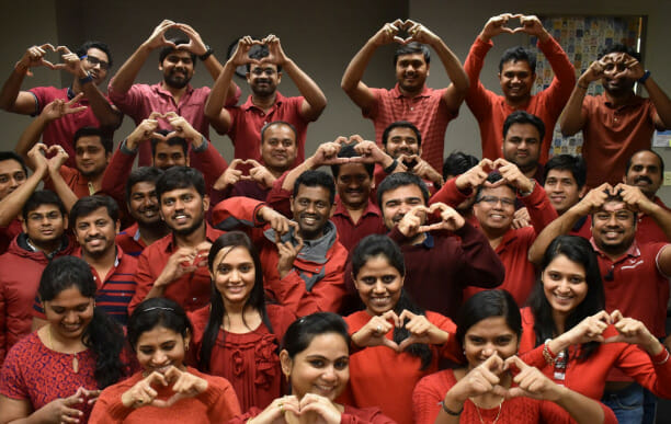 A group of people holding up hearts with their hands.