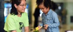 Adult volunteer engages with a young child during a school service project