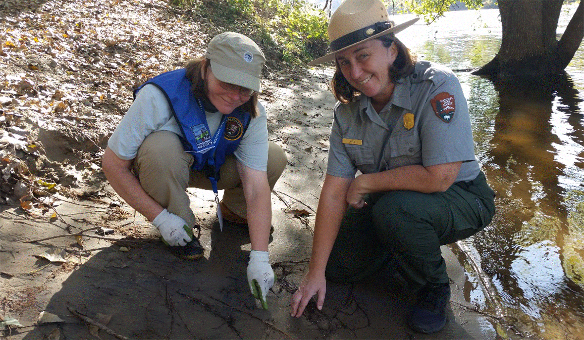 Elizabeth (left) assists park rangers in teaching children about the wonders of the Mississippi River.