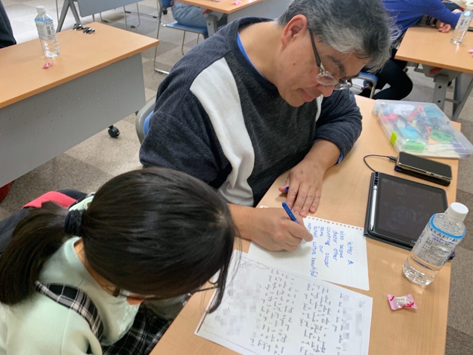 HandsOn Tokyo volunteer works with a student participating in a letter exchange initiative during Golden Week.