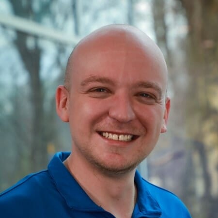 Headshot of a man in a blue shirt.