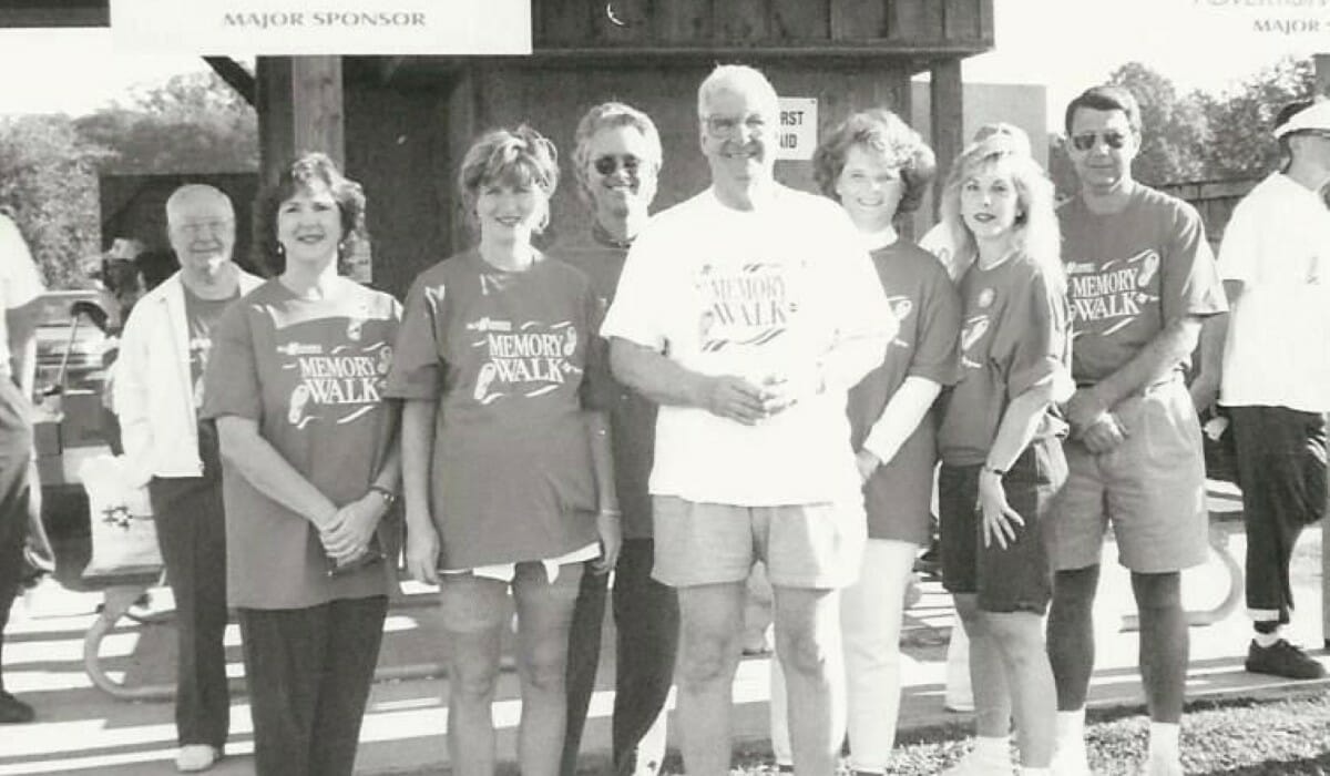 Black and white photo of a group of people standing outdoors wearing Memory Walk t-shirts
