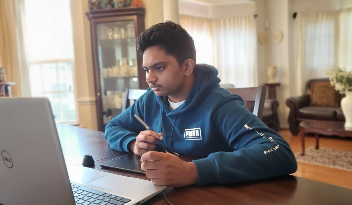 Teenage boy studies at a laptop.