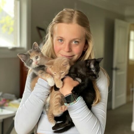 Girl holding three kittens