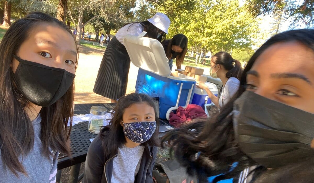 A group of teenagers smiling in a park