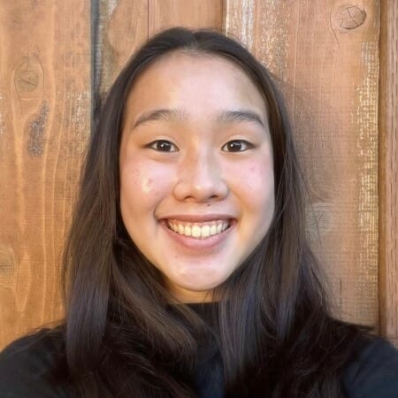 Teenage girl with black hair smiling in a black shirt