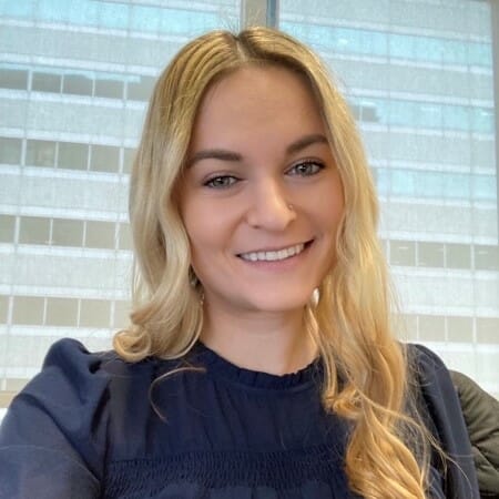 Headshot of a woman with long blonde hair wearing a blue top.