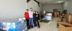 Four people posing together in a large warehouse