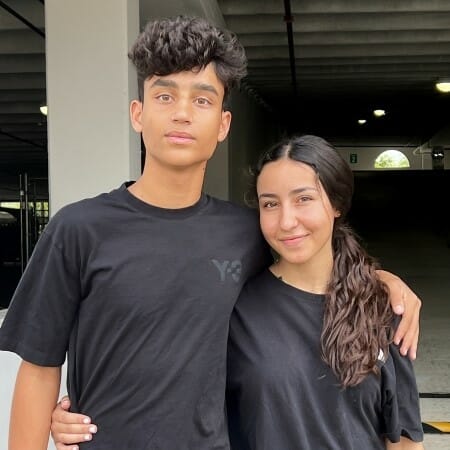 Two teenagers dressed in dark t-shirts.
