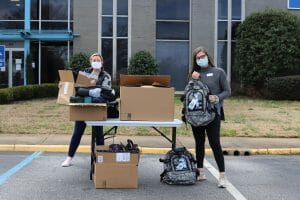 Two volunteers handing out supplies.