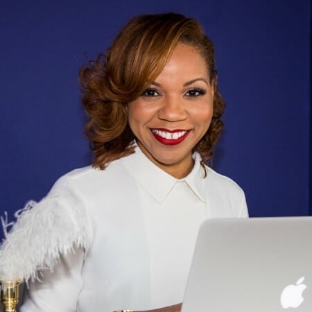 Smiling woman in a white shirt in front of a dark blue background