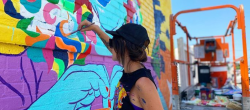 A woman painting a mural.