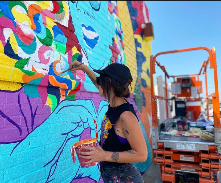 A woman painting a mural.