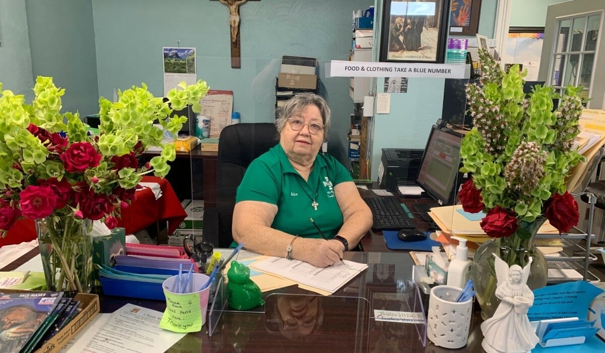 Woman seated at a reception desk.