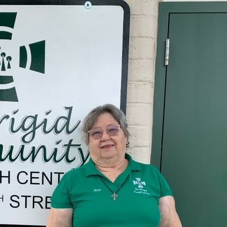 Women in a green shirt standing outdoors.