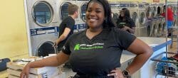 Woman stands smiling in a laundry room.