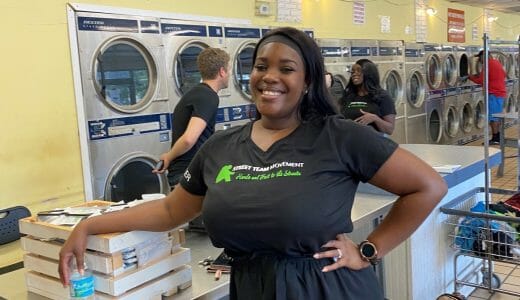 Woman stands smiling in a laundry room.