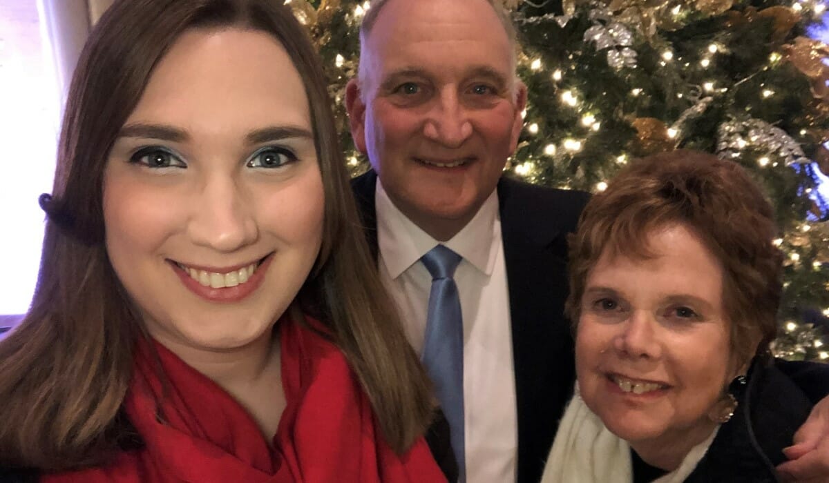 Selfie of three people smiling wearing dress clothes.