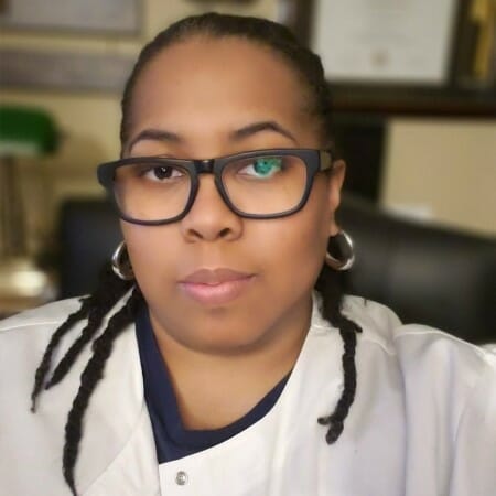 Headshot of a woman in a lab coat and glasses.