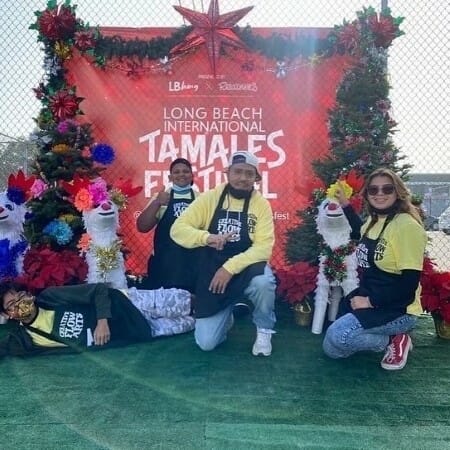 Group of people posing outdoors wearing aprons.