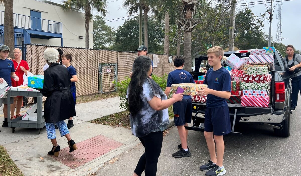 Group of people unload boxes from a truck.