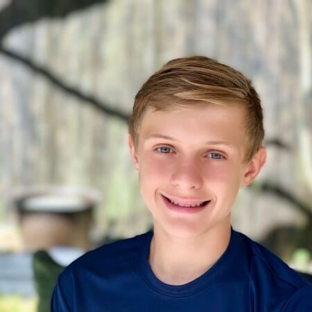 Headshot of a boy in a blue shirt.