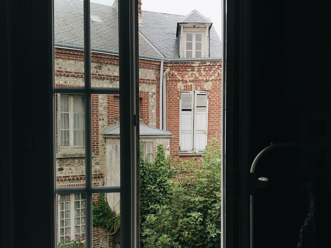 Interior of home looking out toward an antique brick home across the street