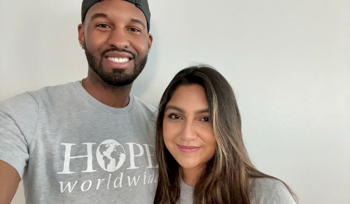 Two people pose together wearing shirts emblazoned with the words "HOPE Worldwide".