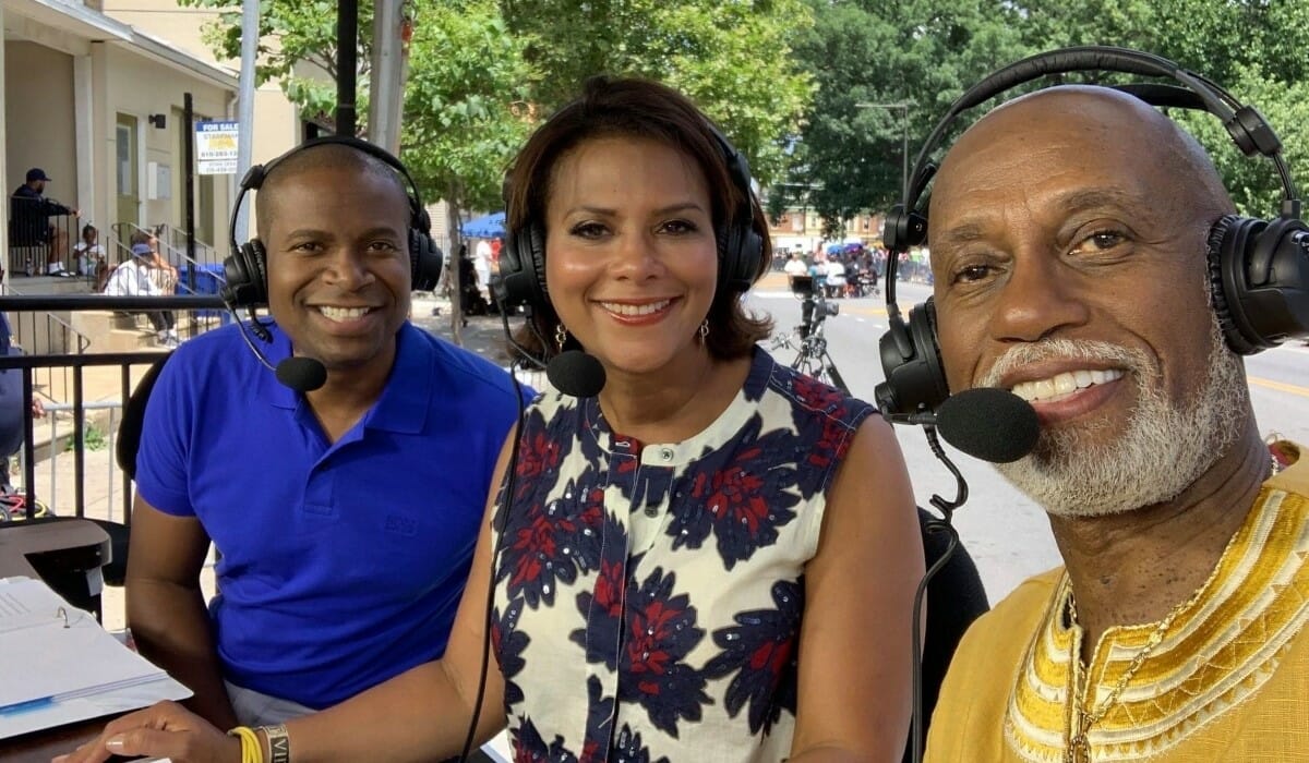 Three people seated wearing headsets.