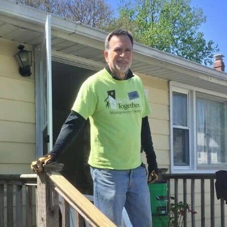 Man walks down the outside stairs of a house.