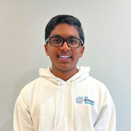 Boy in a white hoodie and glasses.