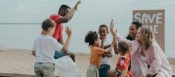 image of families high fiving on the beach