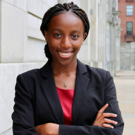 Smiling woman poses with arms folded.