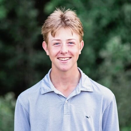 Headshot of a teenager with short brown hair wearing a gray shirt.