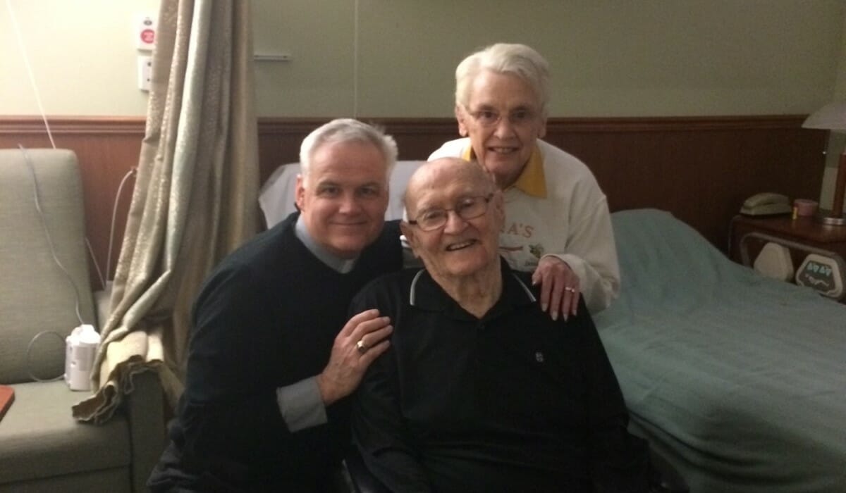 Group of three people with white hair pose together.