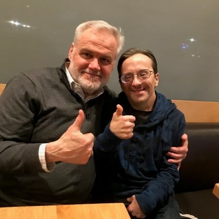 Two seated people giving the "thumbs up" sign.