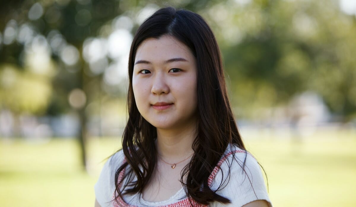 Person with dark hair outdoors.