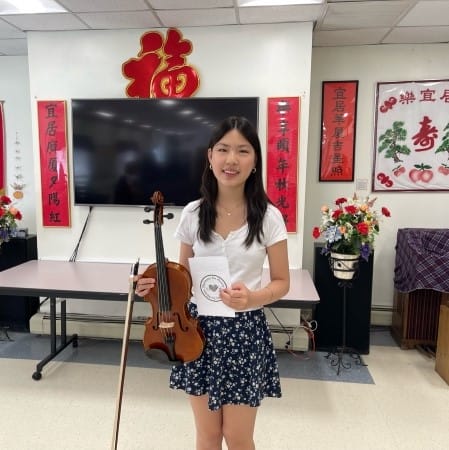 A person smiling holding a viola.